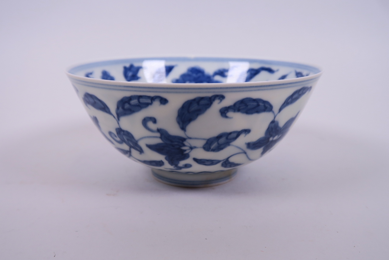 A Chinese blue and white porcelain rice bowl with scrolling floral decoration, 6 character mark to