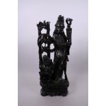 A Chinese carved and ebonised hardwood Quan Yin and child, with inset silver wire decoration, 17½"