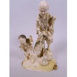 A Japanese carved ivory figure group of a fisherman and child with fish, shellfish and a basket of