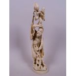 A Japanese carved ivory figurine of a sage with a smaller sage standing on a tree root and a large