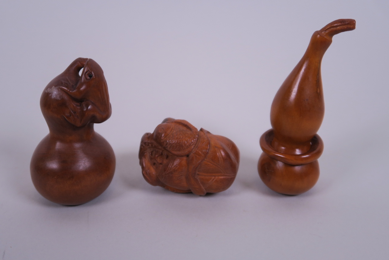 A collection of three carved wood netsuke in the form of gourds, carp and toads, signed to base,