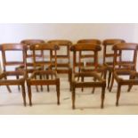 A set of eight Regency birdseye maple dining chairs with carved backs, raised on turned supports,