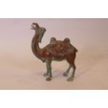 An Oriental patinated bronze figure of a Bactrian camel, with lion mask decorated saddle, 9" high