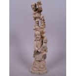 A Japanese carved ivory figurine of a sage standing by a tree with a small child standing in the