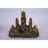 An Oriental bronze brush rest decorated with the immortal Qin Gao riding a carp, 6" long