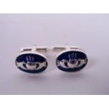 A pair of silver and blue enamel cuff links decorated with a Claddagh design