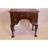 A figured elm lowboy, with three drawers and shaped front, raised on shaped cabriole supports, 30" x