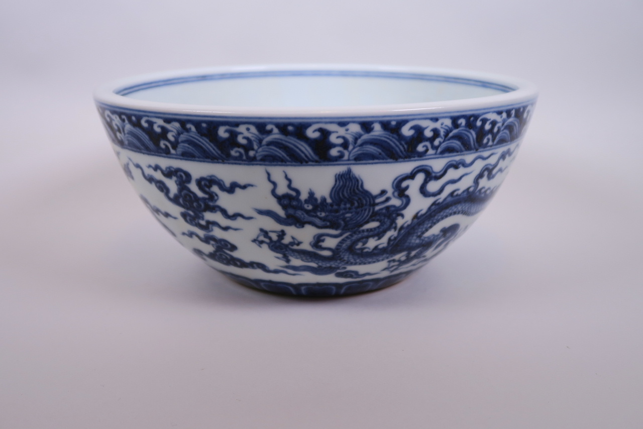 A large Chinese blue and white porcelain bowl decorated with two dragons, 6 character mark to