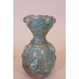 A Middle Eastern blue glazed terracotta jar, with raised brass decoration, 5" high