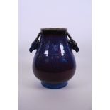 An unusual Chinese pottery vase with two stag mask handles and mauve flambé glaze, seal mark to