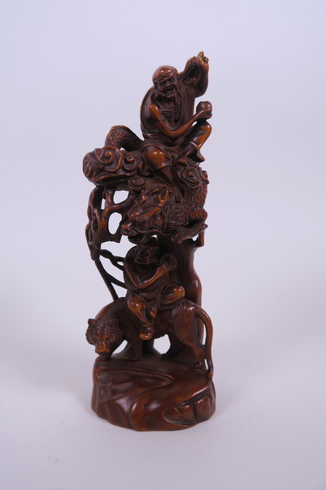 A Chinese carved and pierced hardwood ornament depicting two immortals, 7½" high