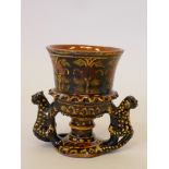 A slipware pottery goblet with polychrome floral decoration and leopard handles, 5" high