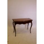 A C19th French inlaid mahogany serpentine shaped card table, raised on shaped supports with gilt