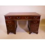A mahogany eight drawer pedestal desk with gilt tooled leather inset top, raised on bracket