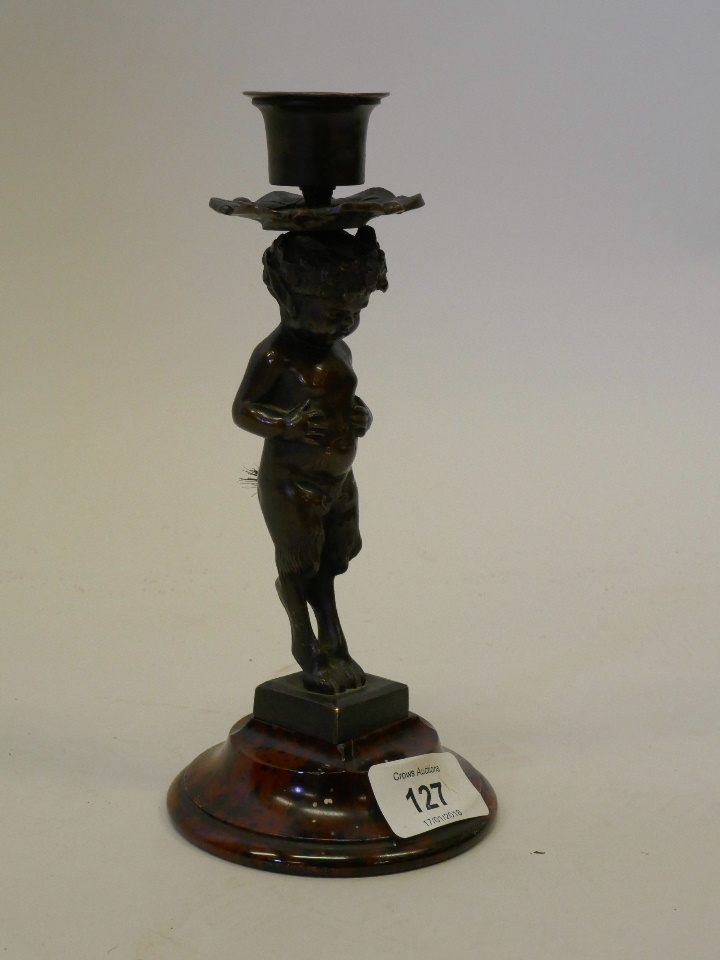 A C19th bronze candlestick in the form of a fawn, mounted on a marble base