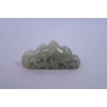 A Chinese celadon jade brush rest with carved deer decoration, 4" long