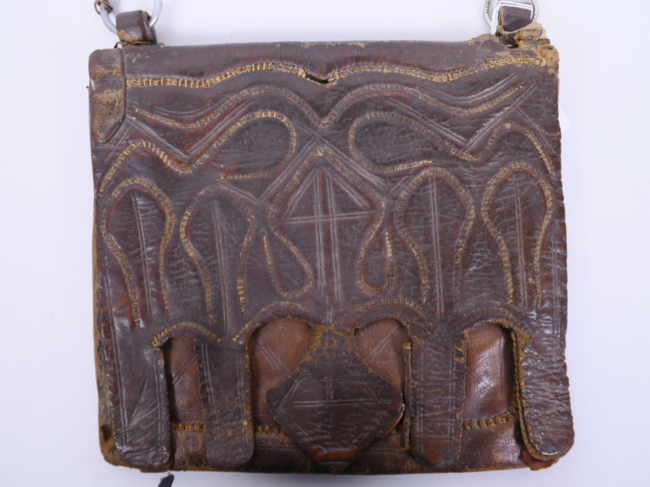 An antique leather Koran case, the front having stitched decoration of Islamic motifs, 11½" x 10"