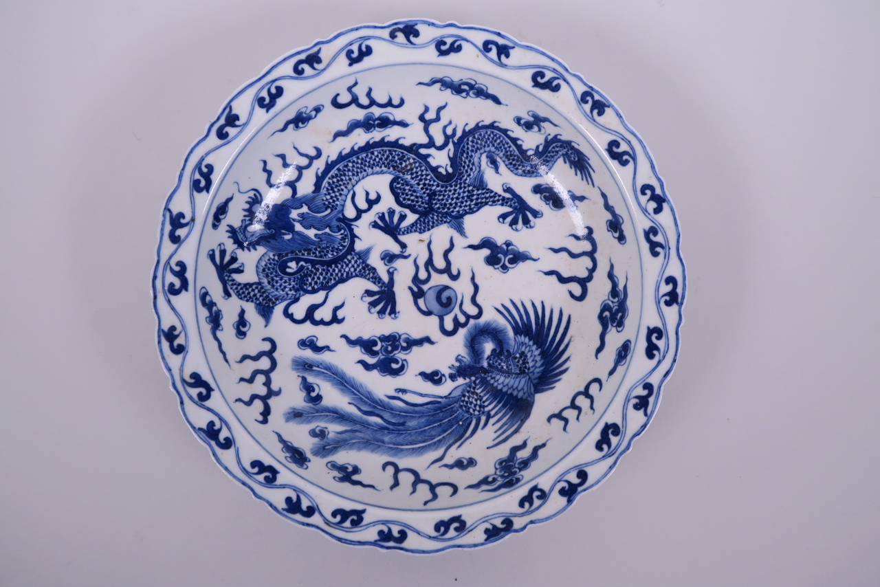 A Chinese blue and white porcelain dish with lobed rim, decorated with a dragon and phoenix