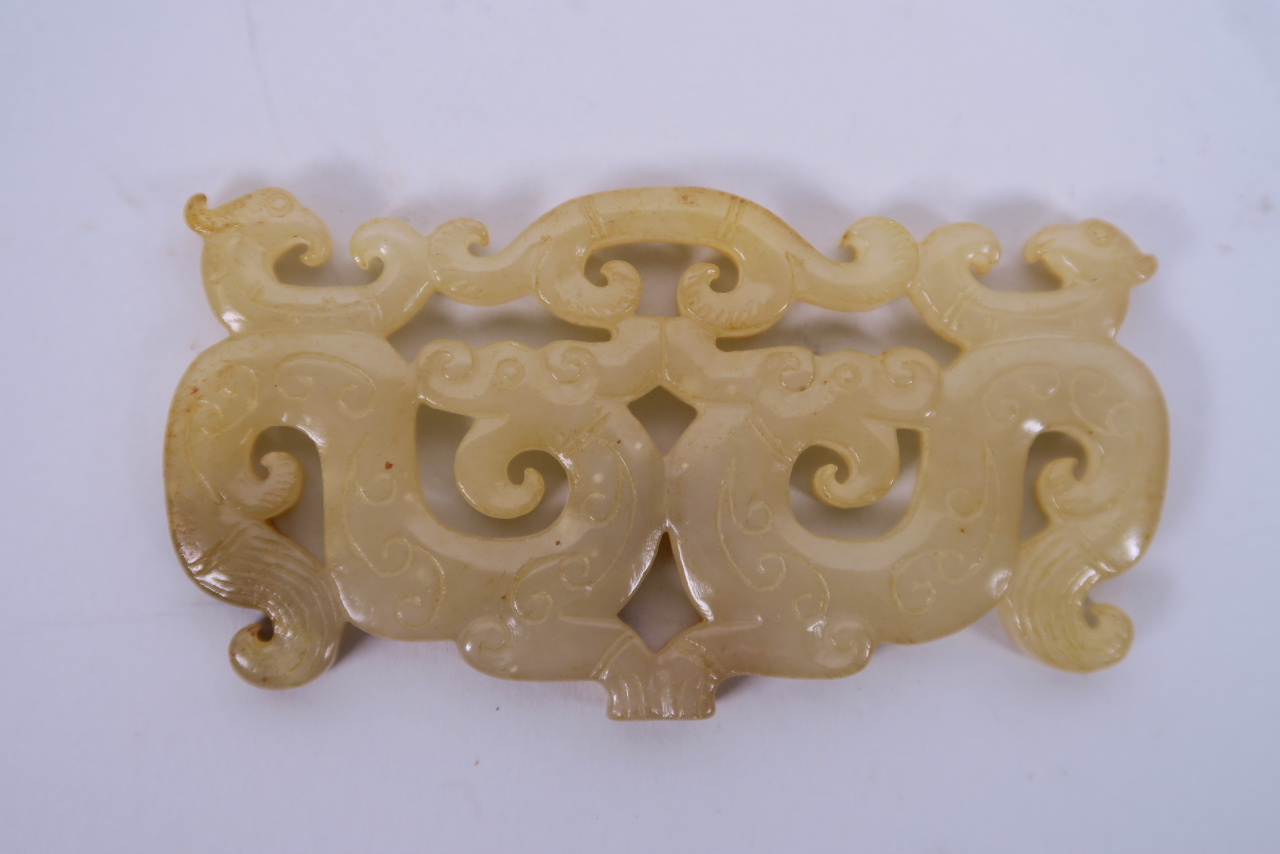 A Chinese carved jade pendant with archaic style dragon and phoenix decoration, 3½" wide