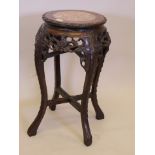 A late C19th/early C20th Chinese carved hardwood jardiniere stand, with pierced frieze and inset