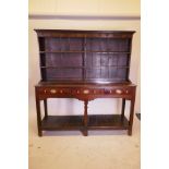 An C18th oak Carmarthenshire Welsh dresser with open Delft rack over three frieze drawers and pot