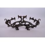 A Chinese bronze brush rest in the form of entwined dragons, 13½" long