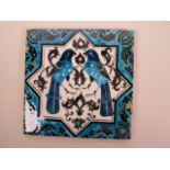 A Turkish ceramic tile decorated in turquoise and black with two birds and Islamic symbols, 7¾"