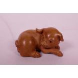 A Japanese carved boxwood netsuke in the form of a pig, 2" long