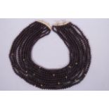 An African 14ct gold and garnet bead choker, 16" long