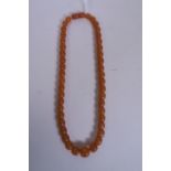A graduated honey amber beaded necklace, with a barrel clasp, 18½" long
