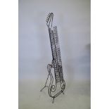 A wrought steel CD rack in the form of a guitar, 53" high