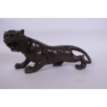 A Japanese bronze figurine of a tiger with chased decoration, 12" long