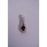 A silver pendant, set with a garnet and encrusted with cubic zirconium, 1" long