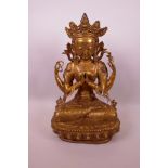 A large Sino-Tibetan gilt bronze figure of a four armed deity, 17½" high