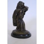 A bronze vesta holder in the form of a monk carrying a wheatsheaf which hides a woman, 8" high