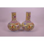 A pair of Chinese famille jaune enamelled porcelain vases decorated with lotus flowers, bats and