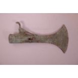 An Islamic patinated bronze axe head decorated with a peacock to the shaft, 9½" long