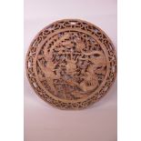 A Chinese circular sandalwood panel carved and pierced with a dragon, phoenix and the flaming pearl,