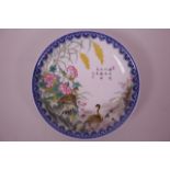 A Chinese polychrome cabinet plate with enamel decoration of birds in a floral landscape, seal