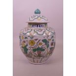 A Chinese porcelain jar and cover of lobed form with yellow and green enamel decoration of carp in a