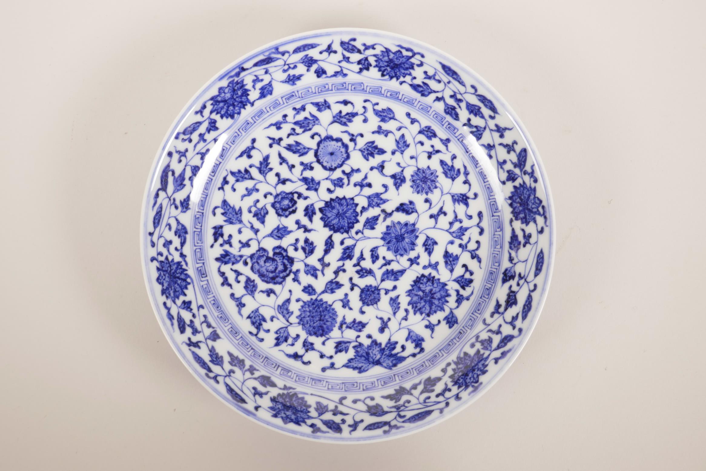 A Chinese blue and white porcelain shallow dish with scrolling floral decoration, seal mark to base,