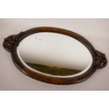 A Black Forest carved wood oval mirrored tray, the handles carved with leaves and flowers, the