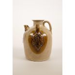 A small Chinese brown glazed wine pourer with raised glazed vine decoration, 4½" high