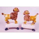 A pair of naive C19th pottery figurines of poodles standing on footstools, possibly Whieldon, 7"