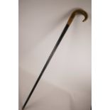 A horn handled and ebonised wood walking stick with a gilt copper mount, handle possibly rhino horn,