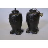 A pair of Oriental painted metal lamps with raised kylin decoration, mounted on wood stands, 12"