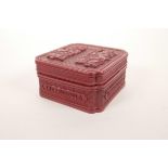 A cinnabar lacquer style box and cover decorated with two immortals and inscribed 'Hong Kong, the