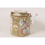 A C19th Cantonese famille rose teapot of cylindrical design, decorated with flowers and panels of