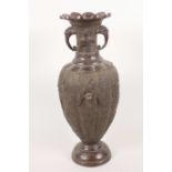 A Japanese Meiji period bronze vase with twin elephant head handles and embossed decoration of birds