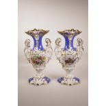 A pair of Continental porcelain two handled urns with floral decoration and gilt highlights, A/F